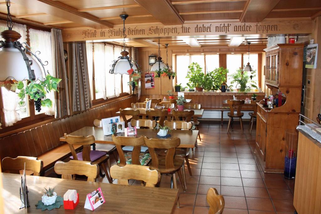 霍伊瑟恩莫斯考宜-盖特恩特亦池酒店餐厅的餐厅设有木桌、椅子和窗户。