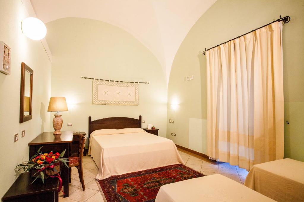 奥里斯塔诺Il大教堂酒店的酒店客房设有两张床和窗户。
