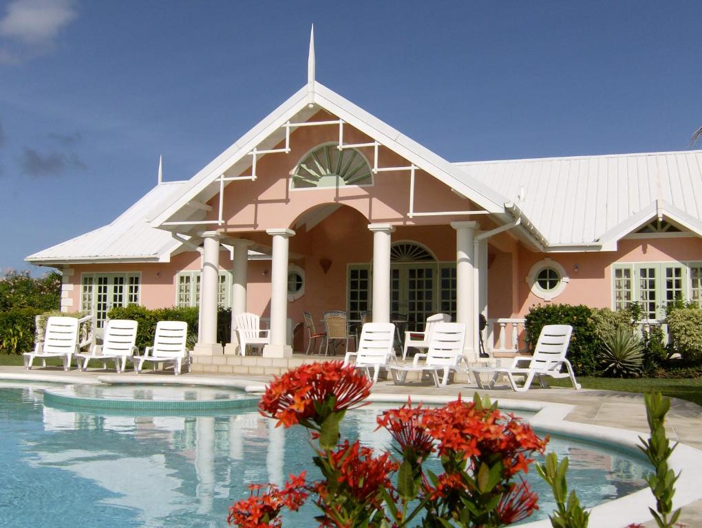 LowlandsVilla Sans-Souci的一座带游泳池、椅子和鲜花的房子