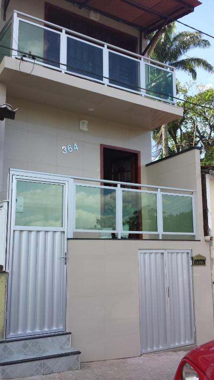 瓜拉米兰加Apartamento Central的白色的房子,设有大门和阳台
