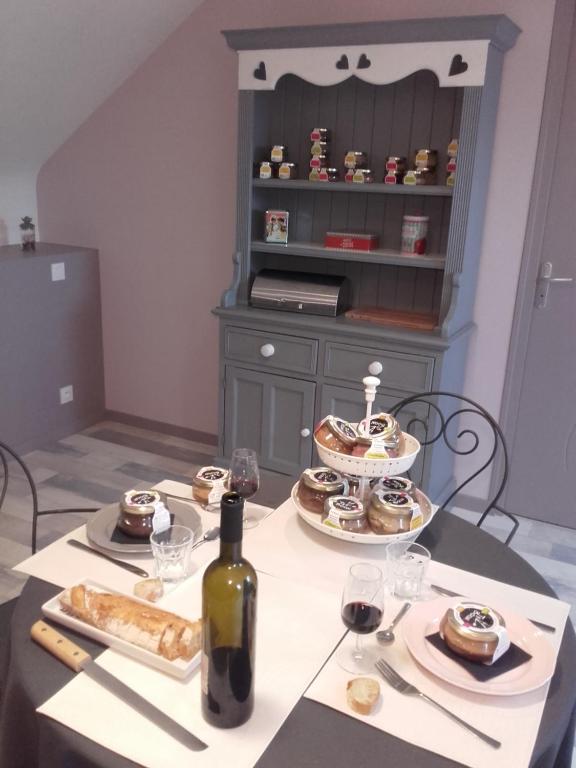 Loscouët-sur-MeuJeanne et Compagnie的一张桌子,上面放着一瓶葡萄酒和一些食物