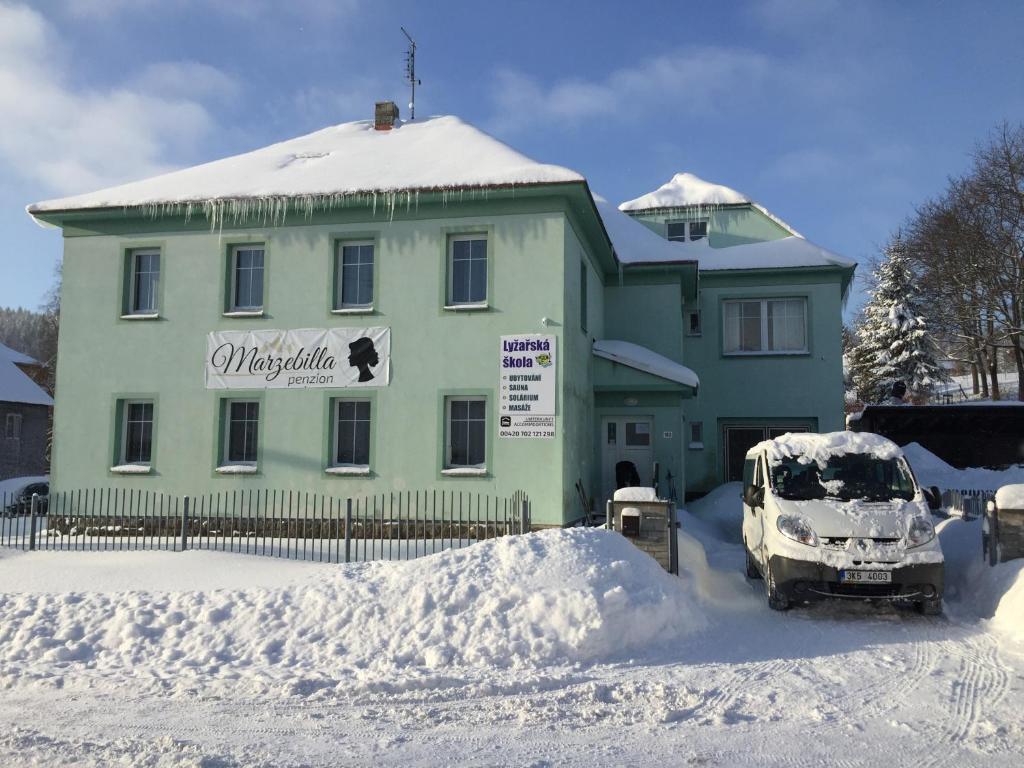 PerninkGuest House Marzebilla Pernink的停在雪覆盖的房子前面的汽车