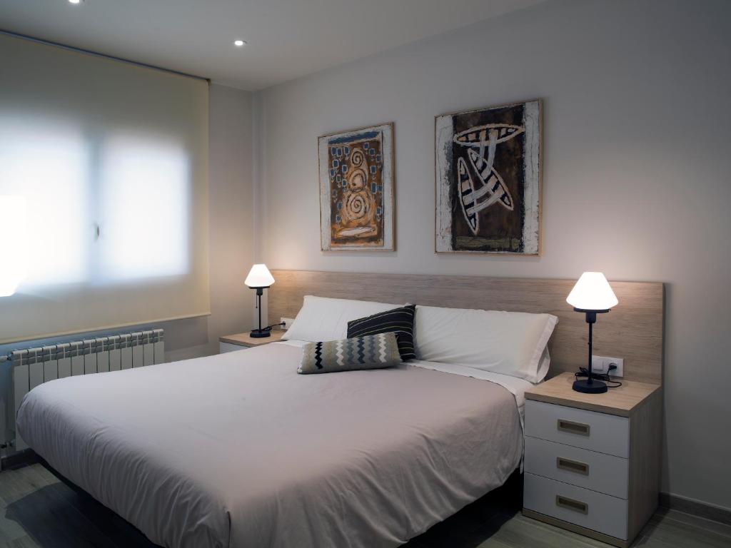 维拉弗兰卡宾纳戴斯卡尔内格里公寓的一间卧室配有一张带两盏灯的大型白色床。