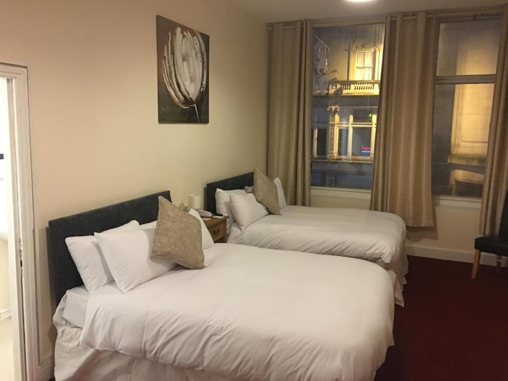 卡迪夫ML旅馆的配有窗户的酒店客房内的两张床