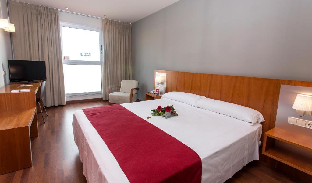 托雷利亚诺Hotel AG Express Elche的酒店客房,配有一张带鲜花的大床