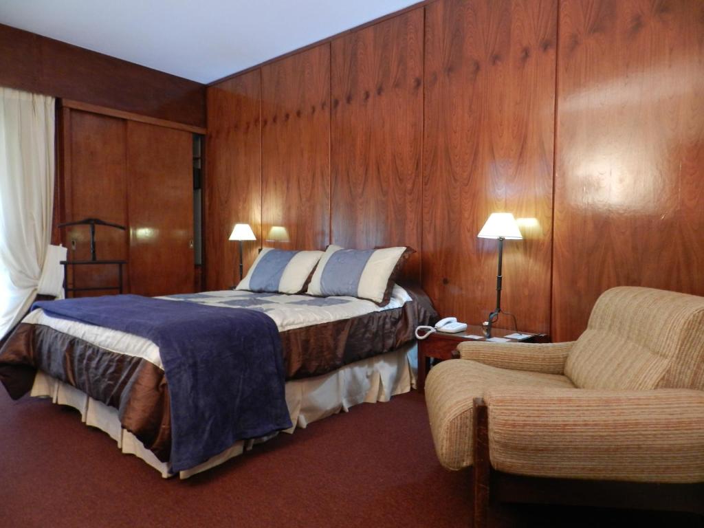 康考迪亚Hotel Ayuí Resort & spa Termal的配有一张床和一把椅子的酒店客房