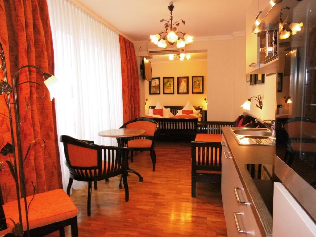 柏林Aparthotel Guzulka & Restaurant的一个带桌椅的厨房和一间客厅