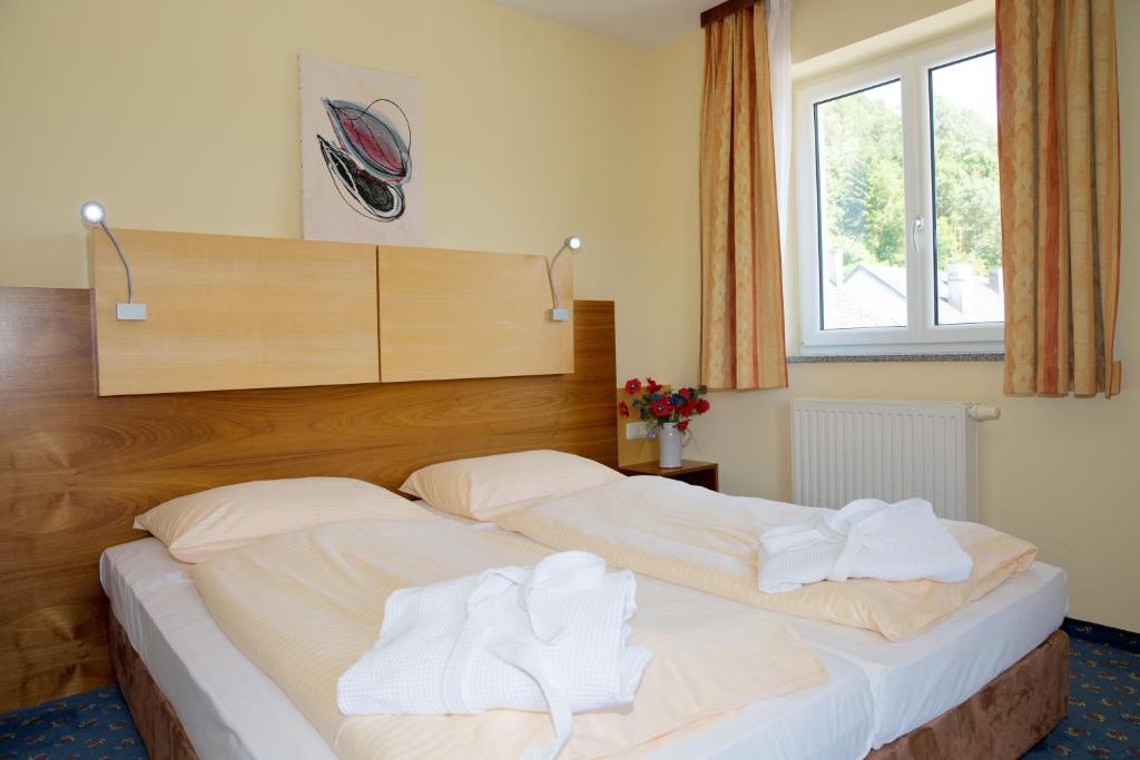 UntermühlGasthof - Landhotel Ernst的一间卧室配有两张床和白色毛巾。