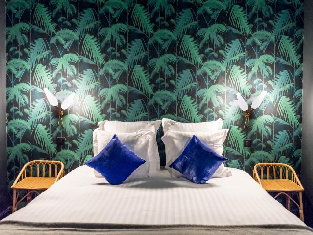 巴黎1er Etage SoPi-Montmartre的一间卧室配有一张带绿色和白色壁纸的床
