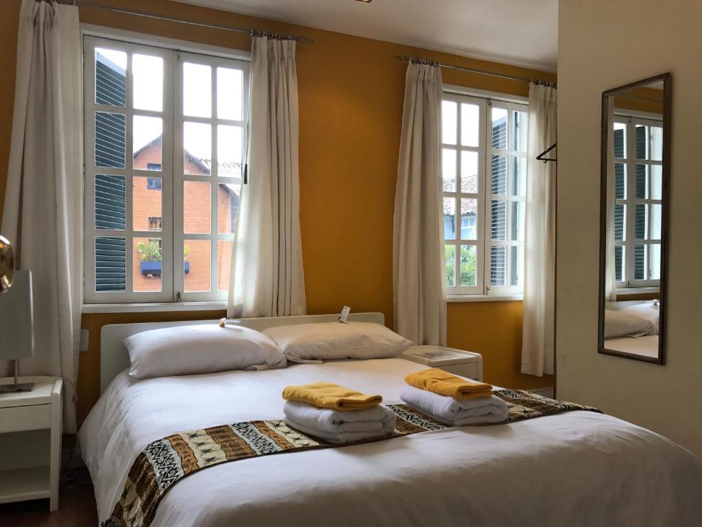 基多开曼酒店的一间卧室配有一张床,上面有两条毛巾