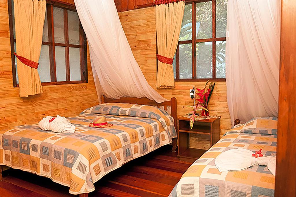 德雷克Pirate Cove的配有木墙和窗户的客房内的两张床