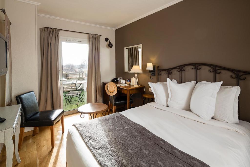 阿维尼翁洛尔洛奇酒店的一间卧室配有一张床、一张书桌和一个窗户。