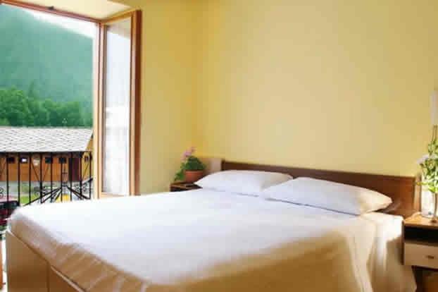 UsseglioHotel Grand Usseglio的卧室设有一张白色大床和一扇窗户。