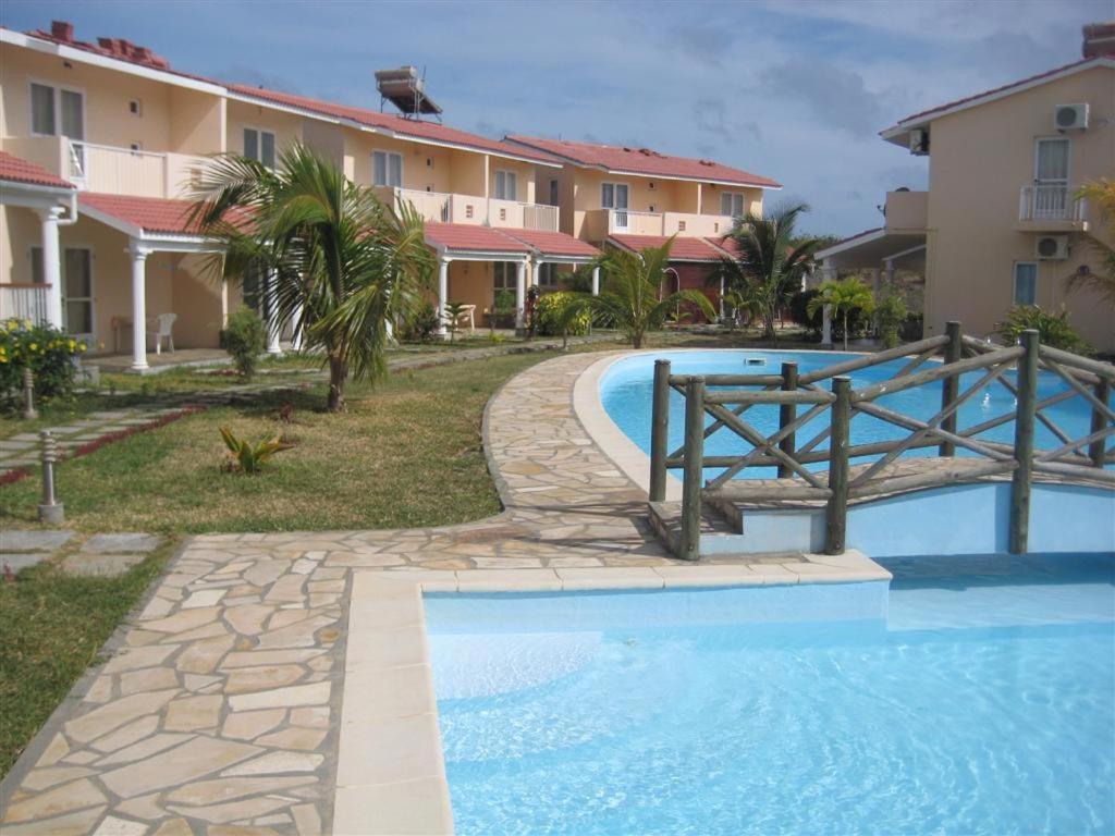 格兰高伯Villa Pupunu 1的一座带游泳池和部分建筑的度假村