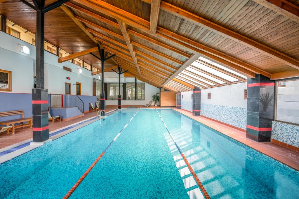 兹内特耶Kopala Tskneti Hotel的一座拥有蓝色海水的室内游泳池