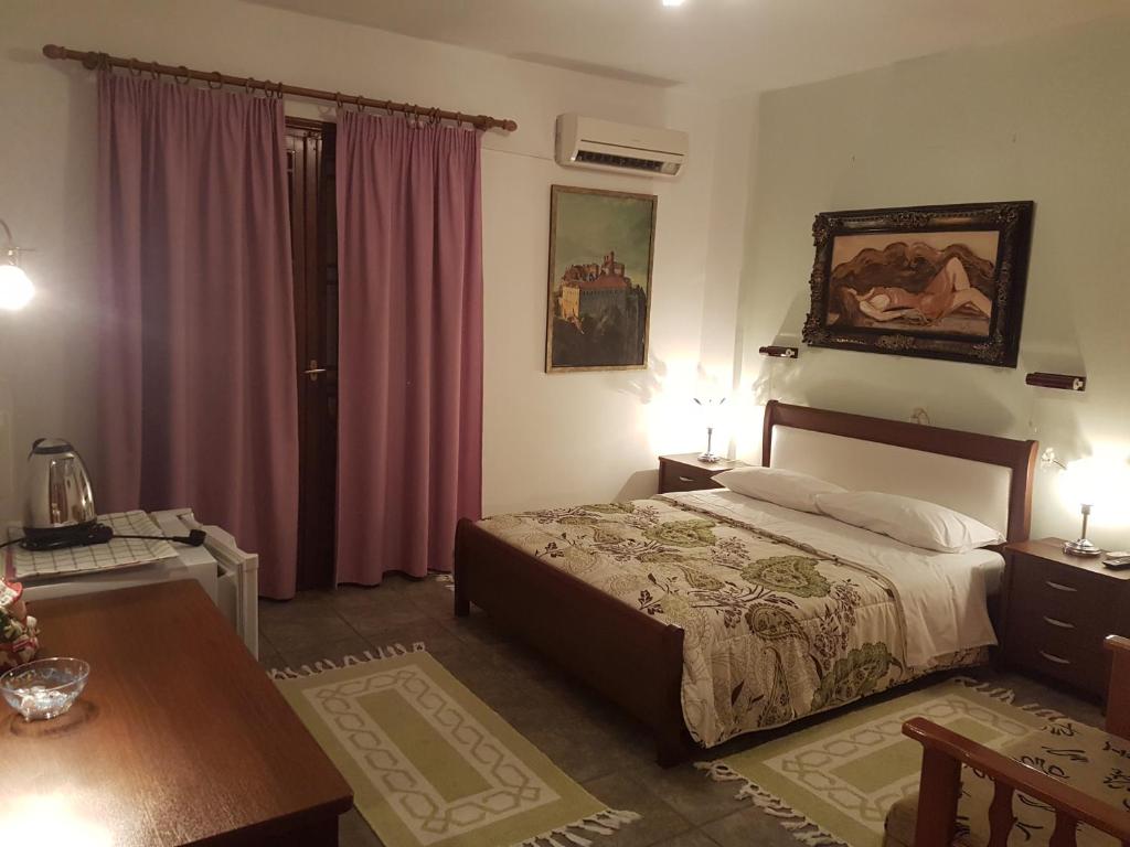 卡兰巴卡索菲亚客栈的一间卧室配有一张床和一张带两盏灯的桌子。