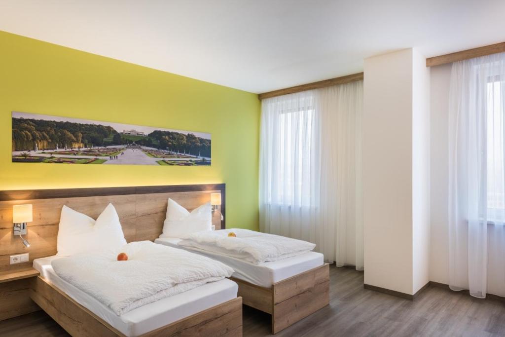 LoosdorfSleepin Premium Motel Loosdorf的一间卧室设有两张床,墙上挂着一幅画