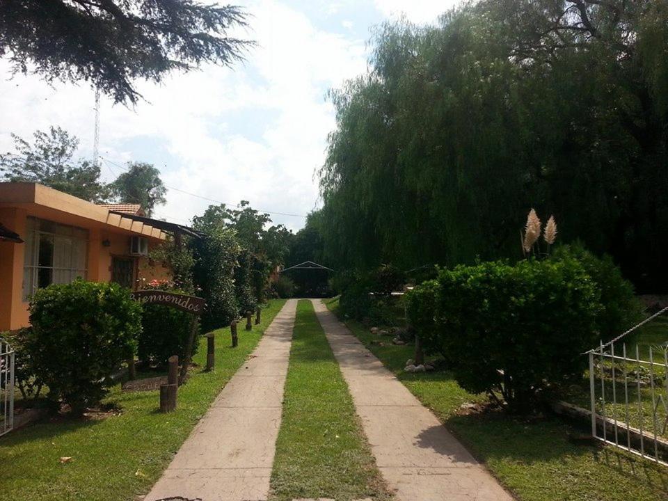 梅洛Residencial Castelar的花园中的一个人行道,就位于房子旁边