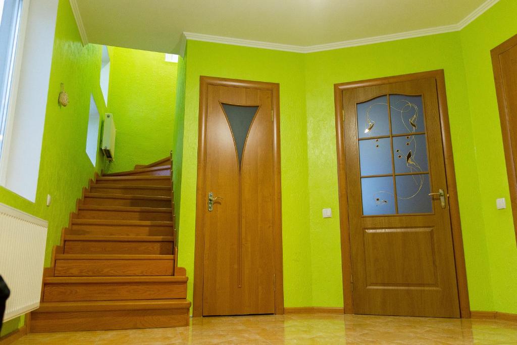卡缅涅茨-波多利斯基Vacation home Lubov的两扇门和楼梯,位于带绿色墙壁的房间