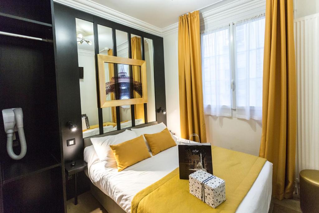 巴黎普拉蒂克酒店的一间卧室配有黄色窗帘的床