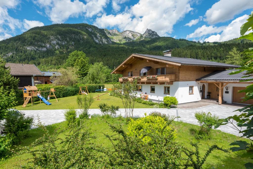 罗孚尔洛弗阿尔卑斯山景公寓的一座带游乐场和山脉的房屋