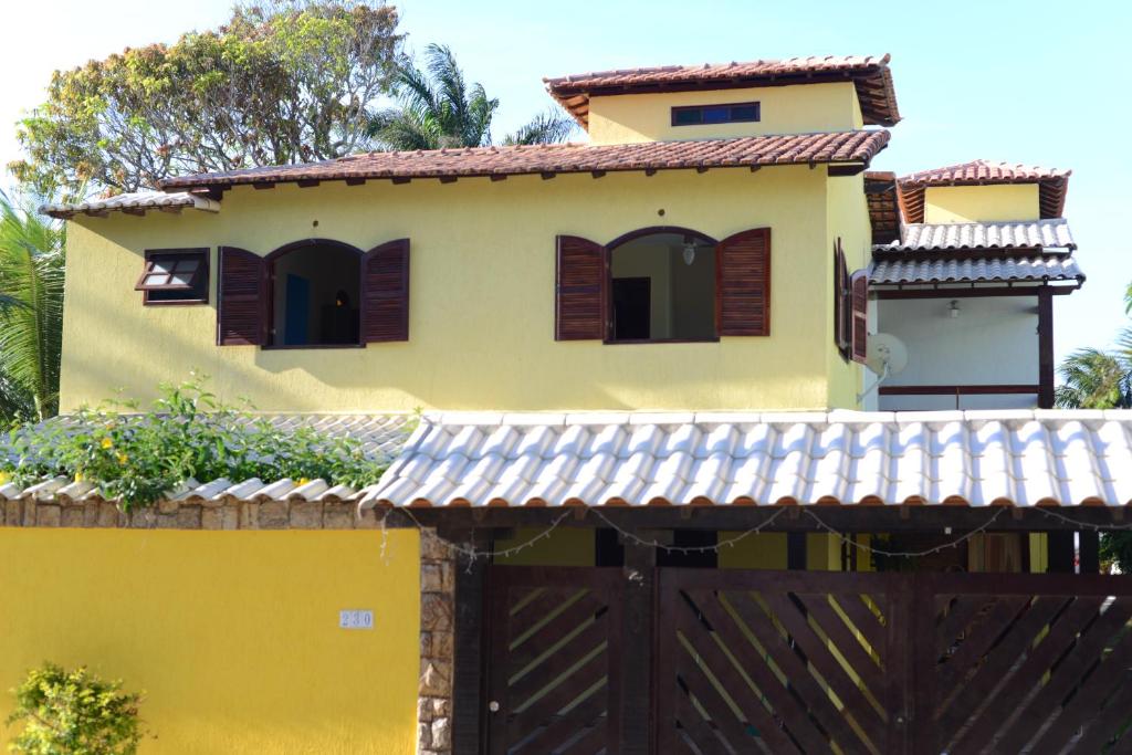 萨夸雷马Pousada Paraíso de Itaúna的黄色的房子,有门和栅栏