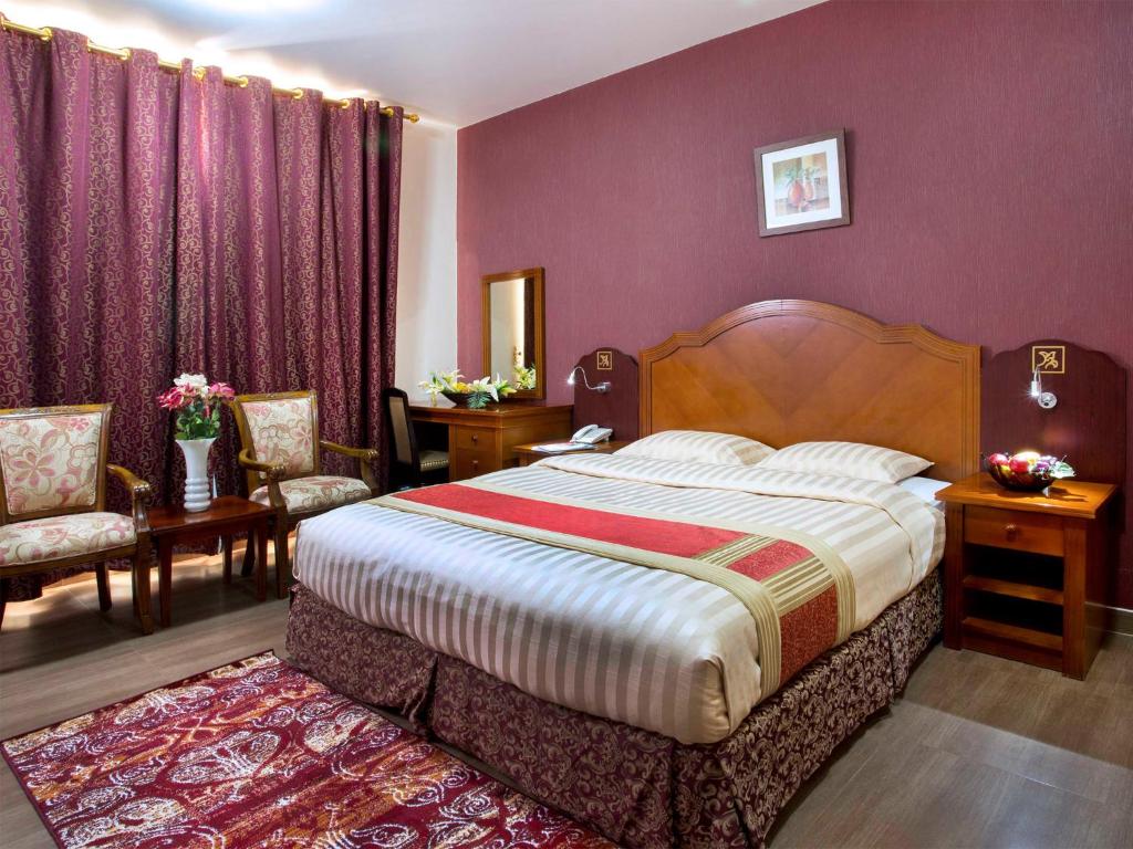 马斯喀特萨费酒店套房的一间卧室设有一张紫色墙壁的大床
