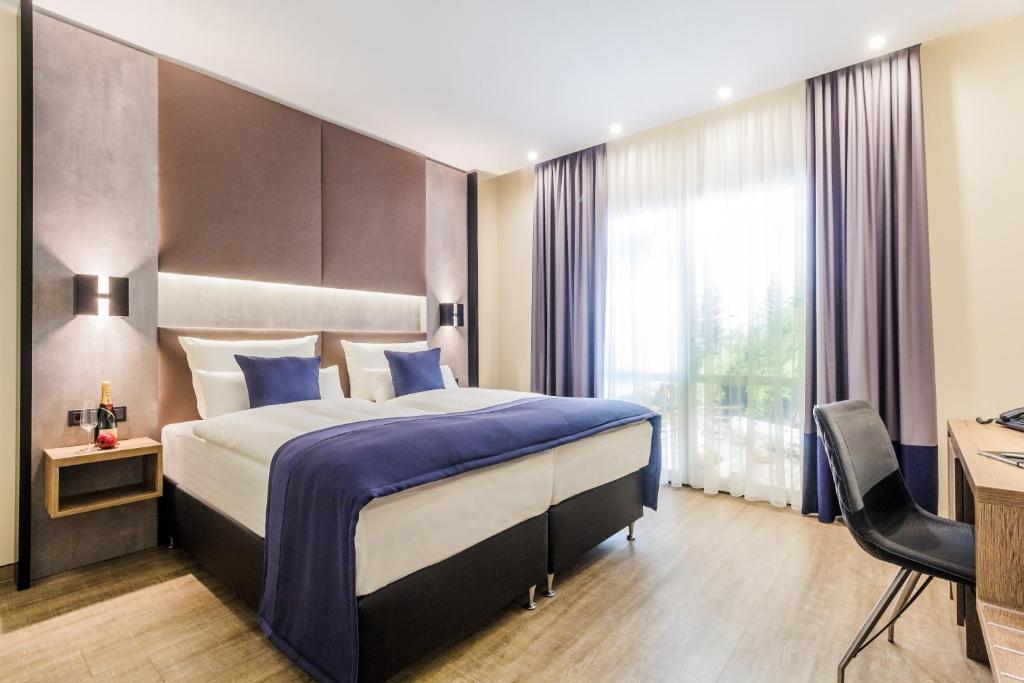 克洛彭堡SKY Hotel Cloppenburg的配有一张床和一张书桌的酒店客房