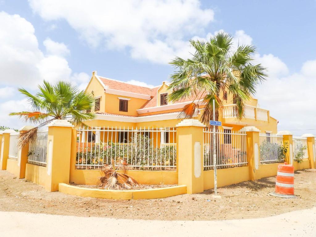 克拉伦代克Landhuis Belnem Bonaire的棕榈树前方的黄色房子