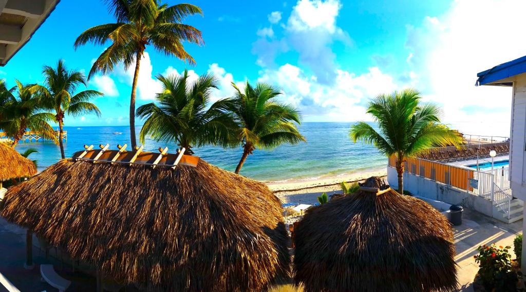 马拉松克殖民地海滩汽车旅馆的棕榈树和草屋海滩,海洋