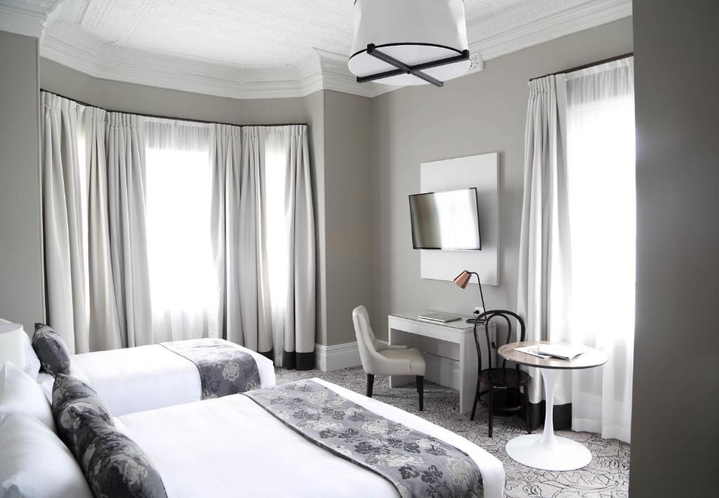 悉尼The Lurline Randwick的酒店客房配有两张床和一张书桌