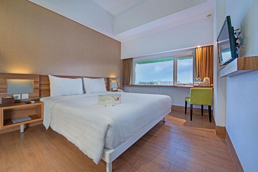 巴厘巴板巴厘巴板薇姿普瑞木酒店 的酒店客房设有一张大床和一张书桌。