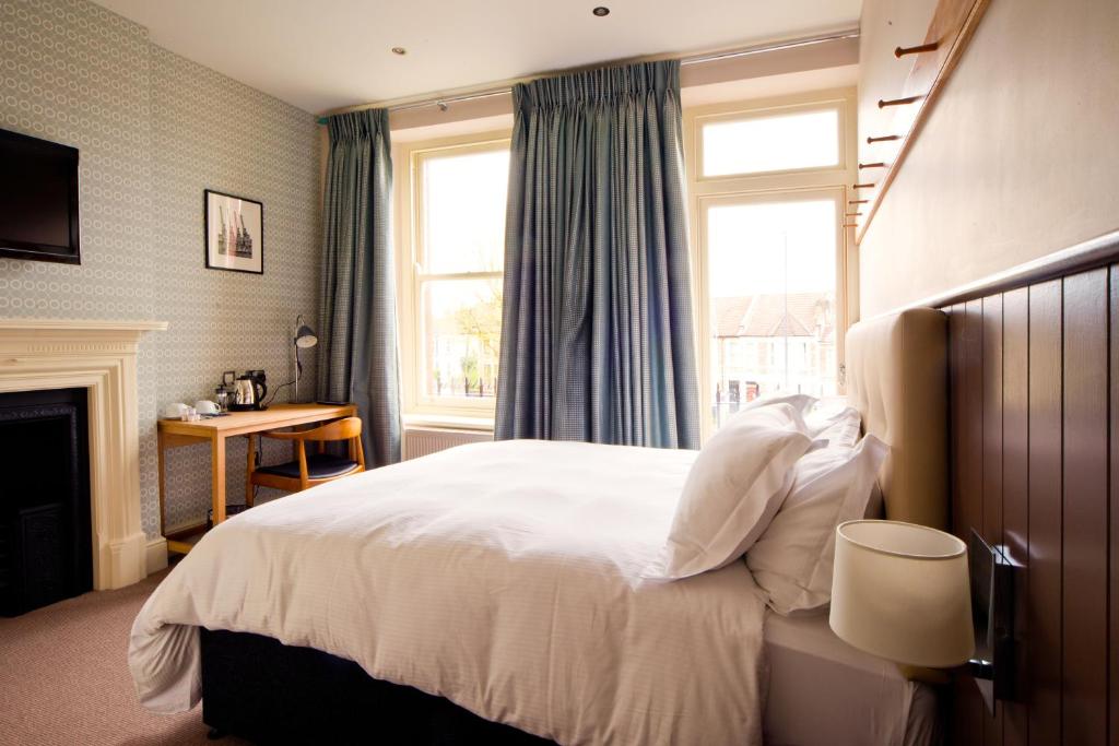 布里斯托惠灵顿酒店的卧室配有一张白色大床和壁炉