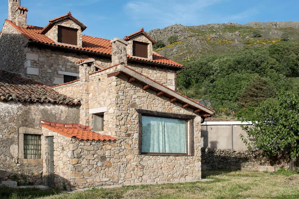 CabezabellosaCasa Rural Romanejo的一面有窗户的石头建筑