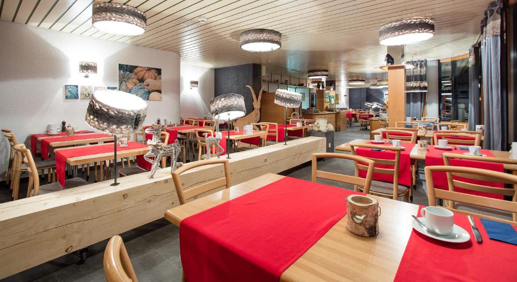 克莱恩 蒙塔纳杜拉克酒店的餐厅配有桌椅和红色桌布