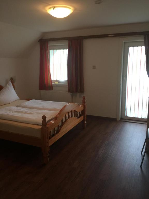 Jenig费瑞恩斯达斯维特酒店的一间卧室设有一张床和两个窗户。