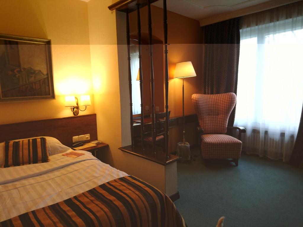 拉绍德封阿特摩斯酒店的配有一张床和一把椅子的酒店客房