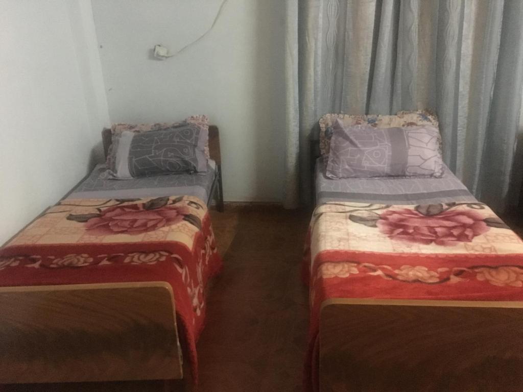 杰里科Sami Hostel的两张睡床彼此相邻,位于一个房间里