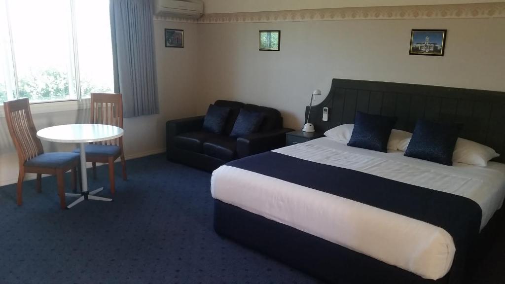 亚拉腊亚拉特南十字汽车旅馆 的配有床、椅子和桌子的酒店客房