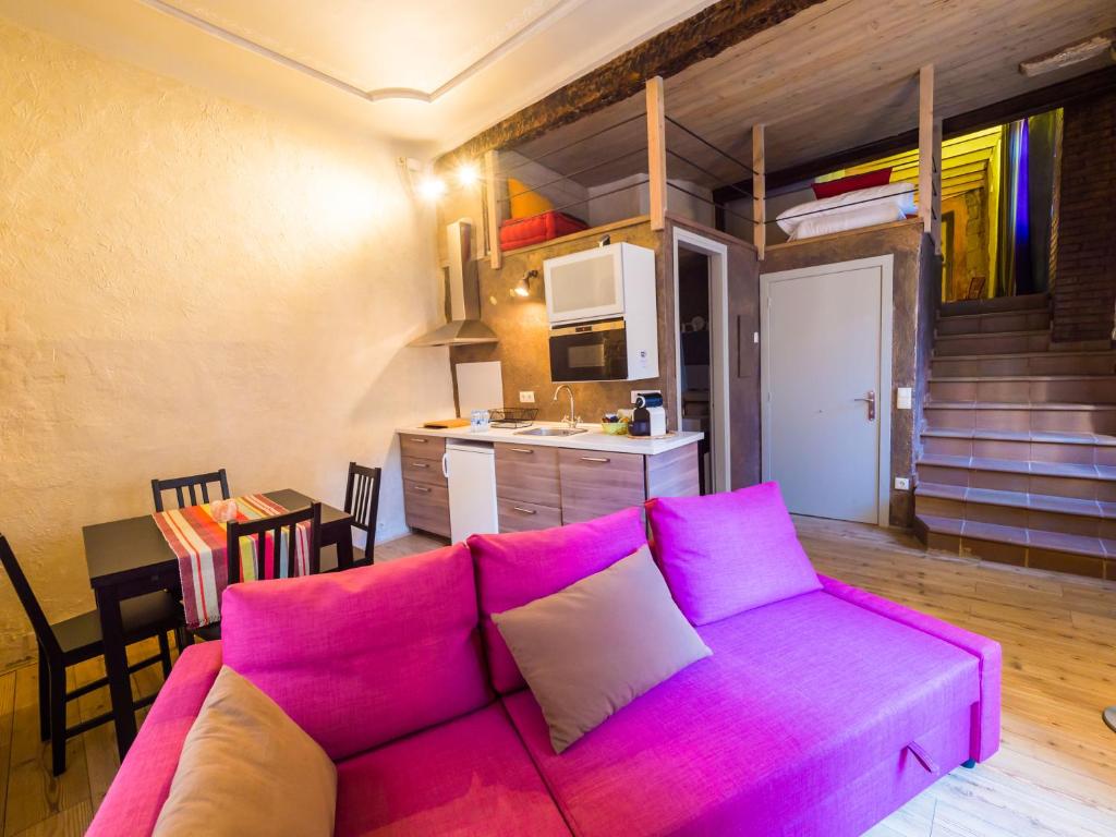 卡尔多纳El Mercadal的一间带紫色沙发的客厅和一间厨房