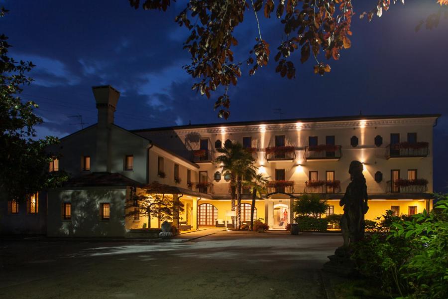 斯科尔泽穆里诺安蒂科酒店的一座大建筑,在晚上有雕像在前面