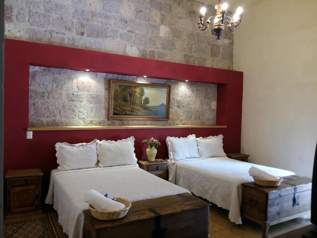 莫雷利亚利蒙切罗住宿加早餐旅馆的一间卧室设有两张床和红色的墙壁