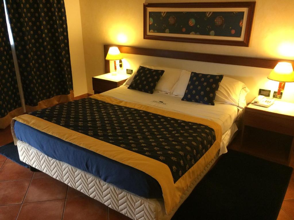 Villanova Monferrato阿尔括特尔酒店的酒店客房带一张大床和两张桌子
