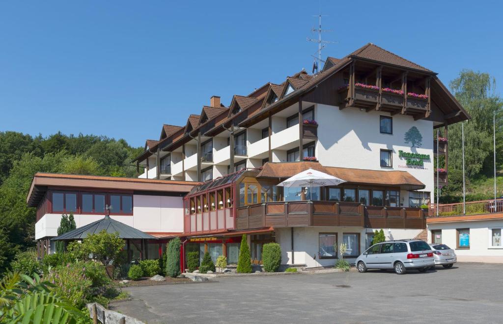 HeimbuchenthalPANORAMA Hotel Heimbuchenthal的大型酒店,停车场内有车辆停放