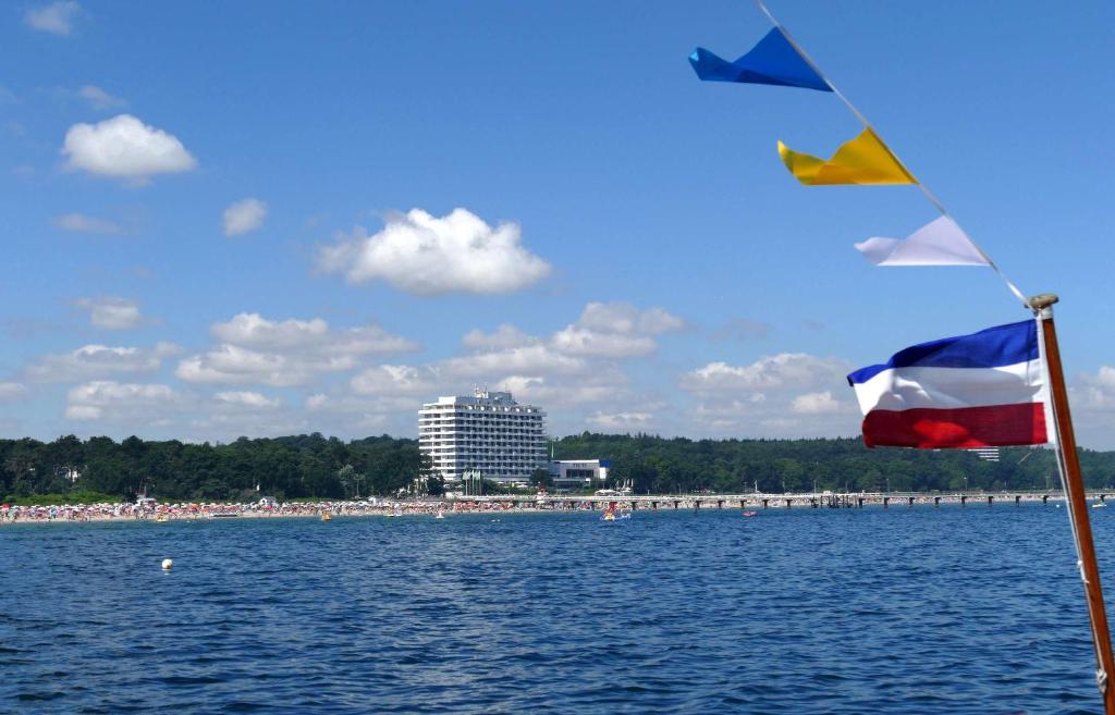 蒂门多弗施特兰德玛丽蒂姆提蒙多夫斯特瑞德海景酒店的享有海滩美景,船上悬挂着国旗