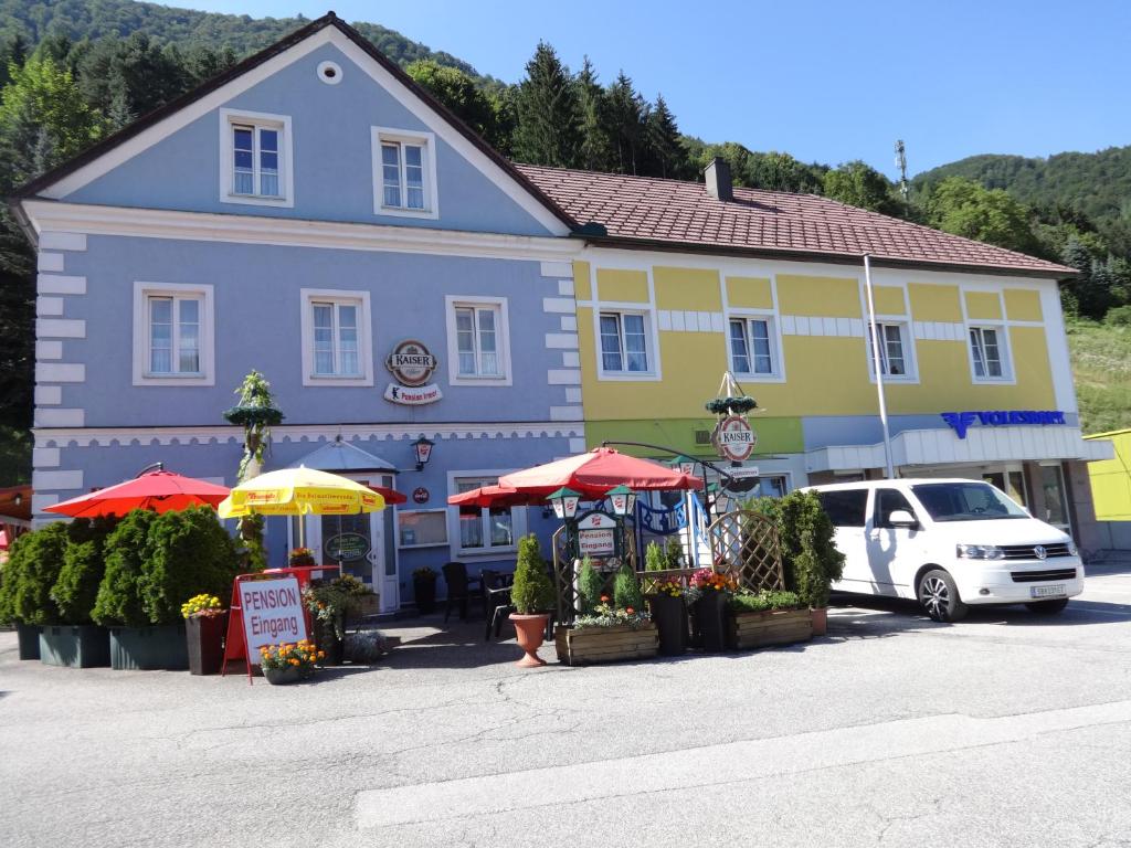 GamingFrühstückspension Irmer的蓝色和黄色的建筑,前面有雨伞
