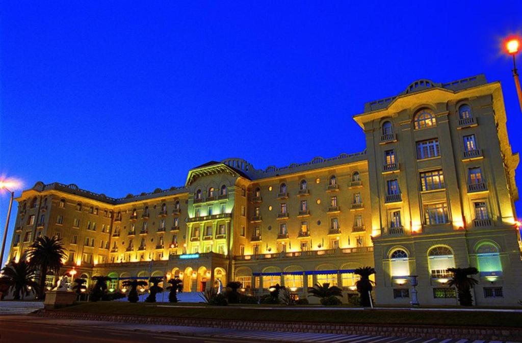 皮里亚波利斯阿根廷赌场和度假酒店的一座大型建筑,人们在晚上站在外面