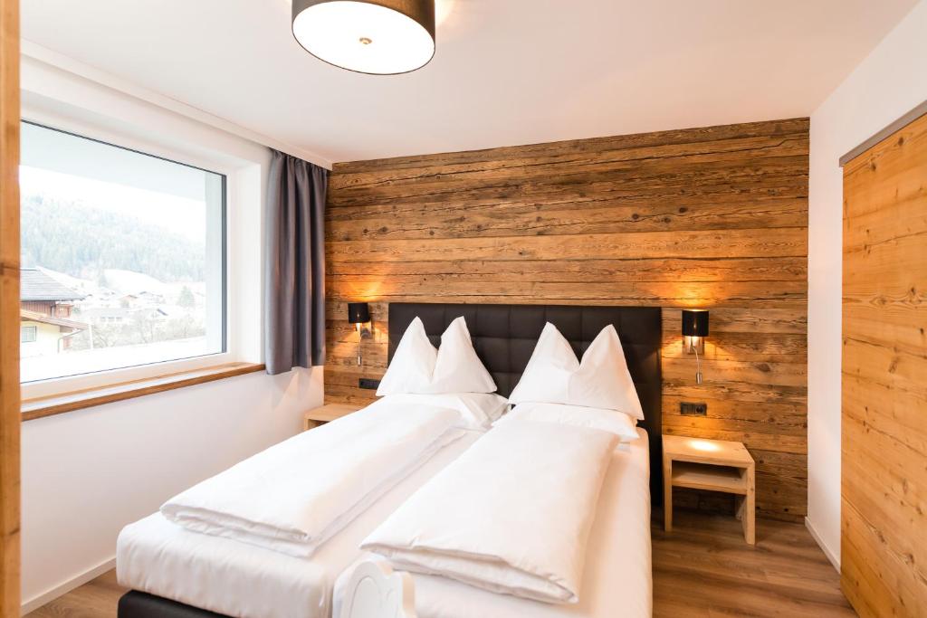 弗拉绍APART Forellenhof的一间卧室设有一张带木墙的大床
