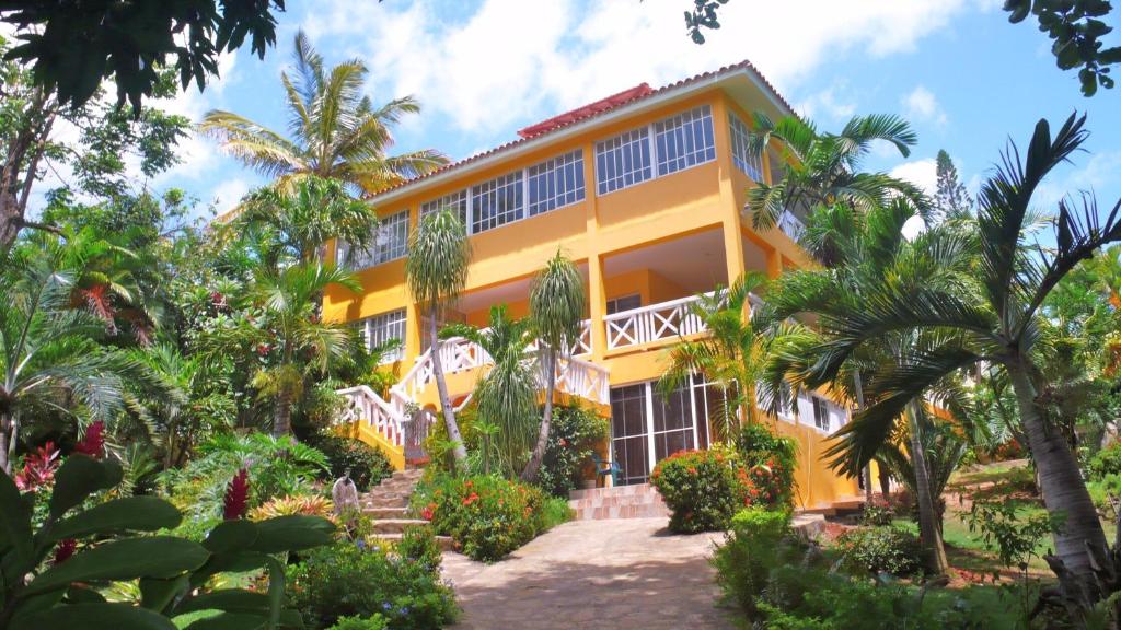 圣斐利-银港卡萨热带酒店的一座棕榈树的黄色建筑