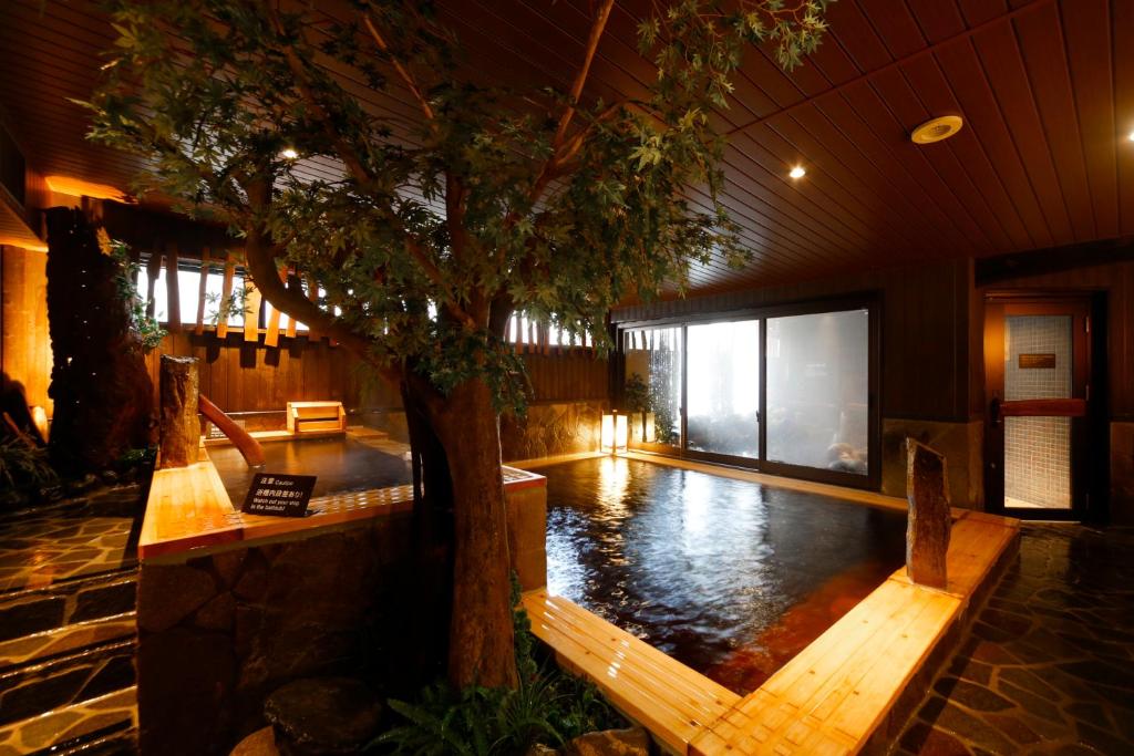 富山多美迎富山酒店的一座建筑物中间有树的游泳池